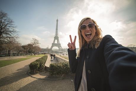 GoingSolo-WomanParisPeaceSymbolSelfie-iStock
